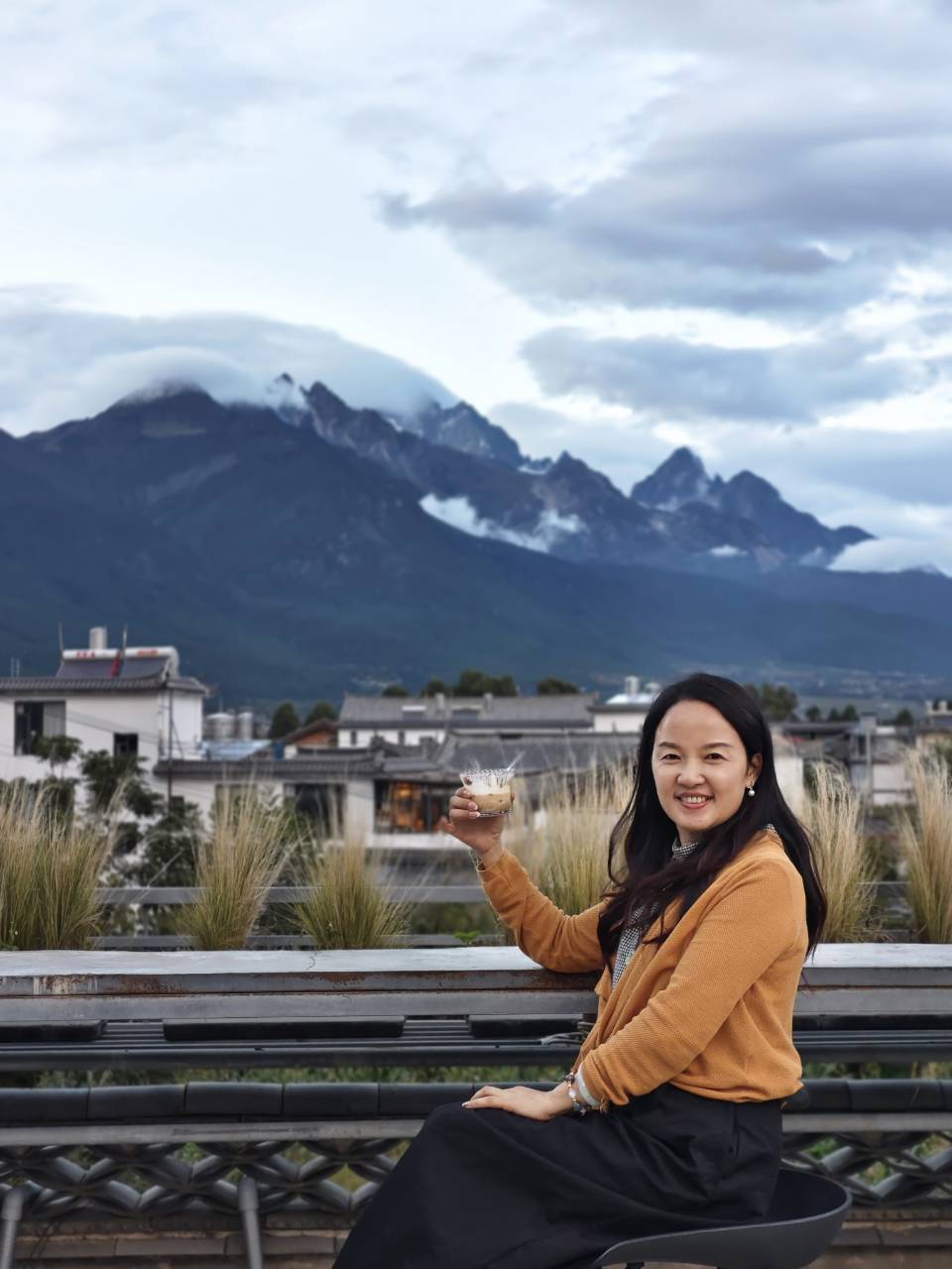 树咖啡屋顶上举杯与雪山合影
