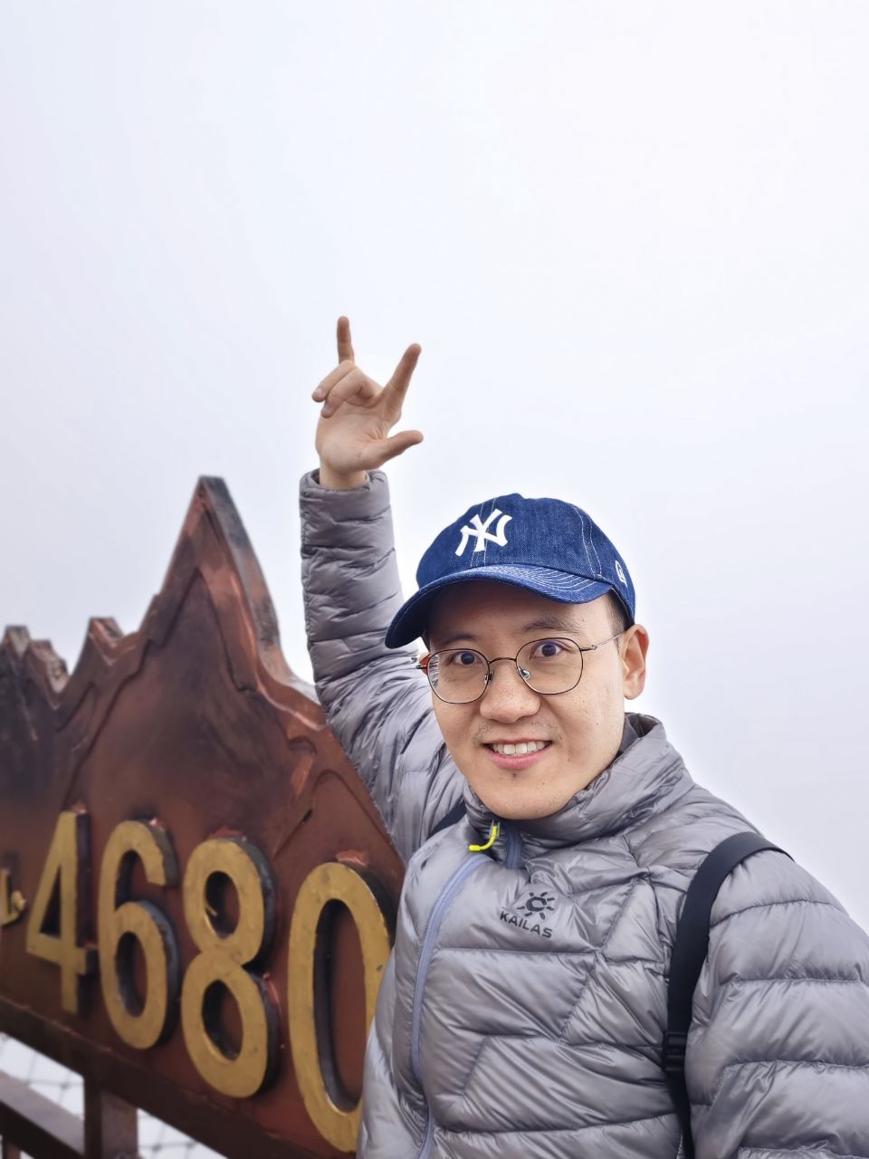 玉龙雪山4680米标志前举手的游客留影