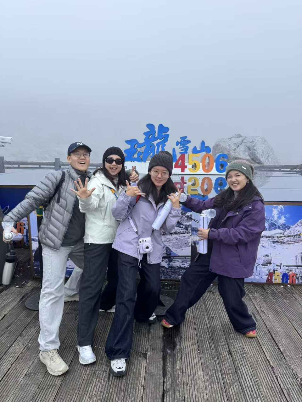 玉龙雪山4506米标志前的一家四口合影