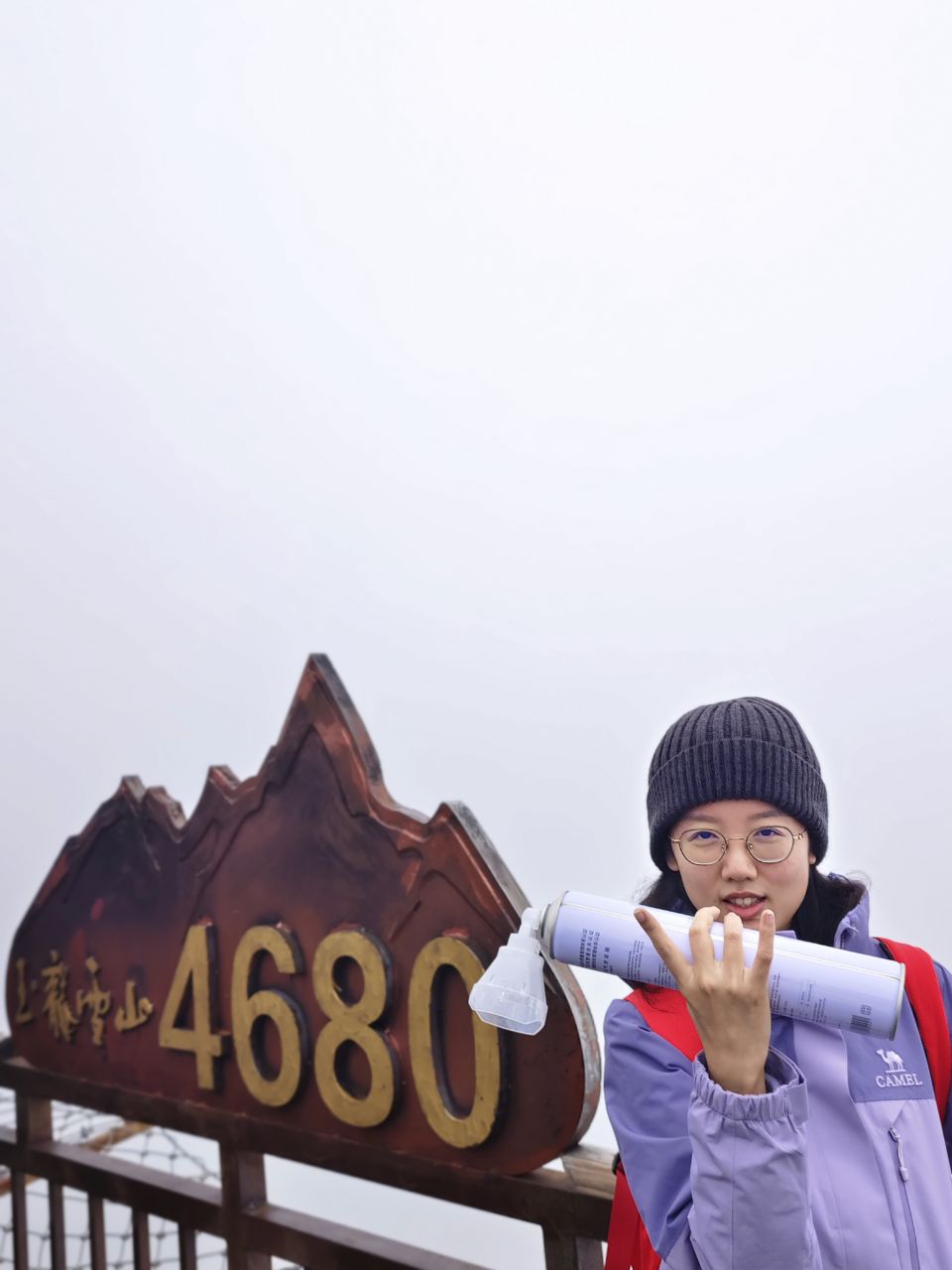 玉龙雪山4680米标志前手拿氧气的留影