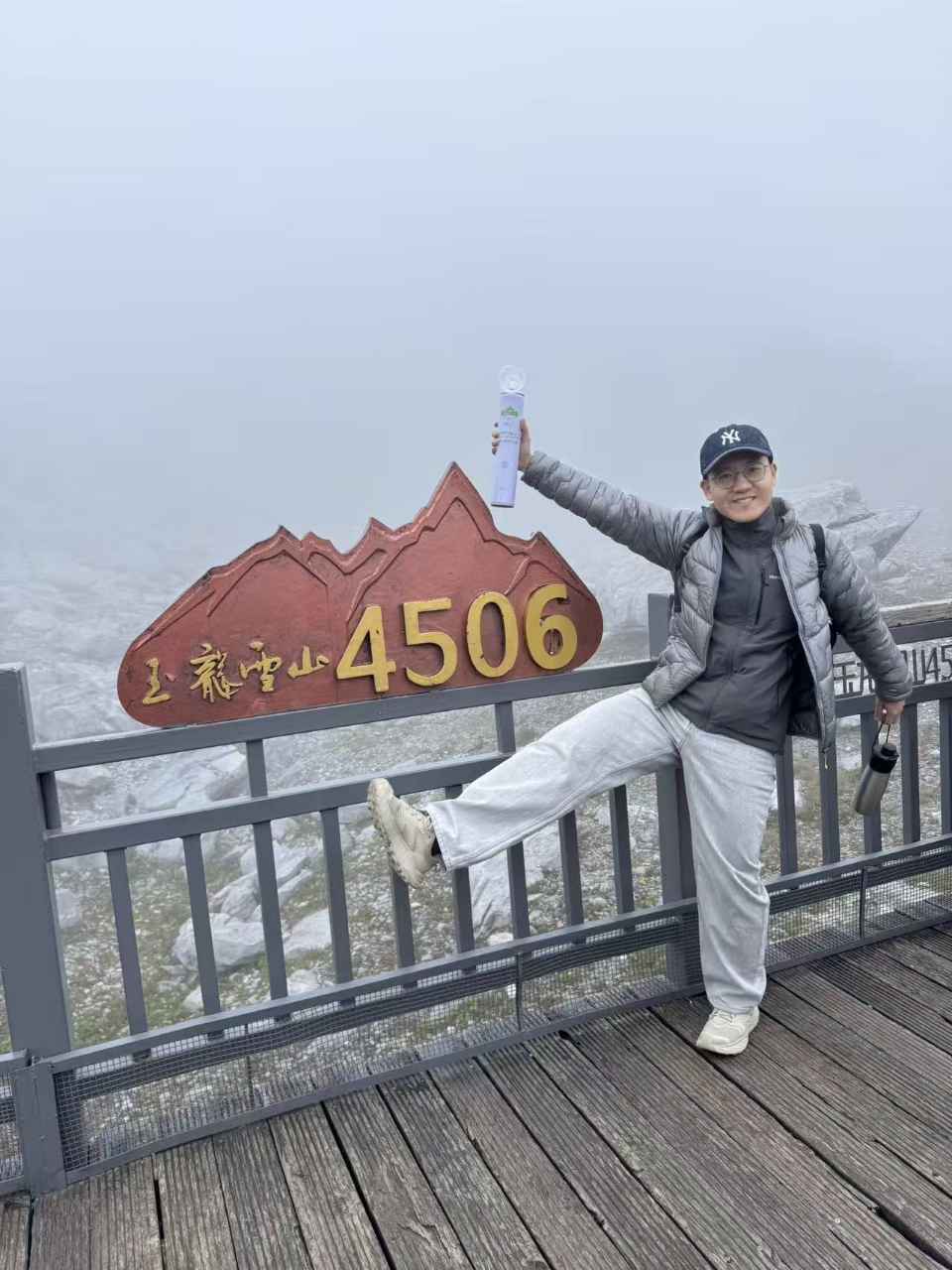 玉龙雪山4506米标志前举起氧气的留影