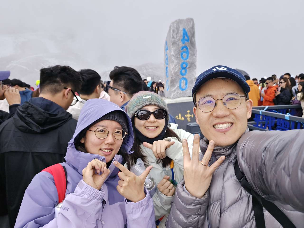 4680米标志前人群中的三人合影