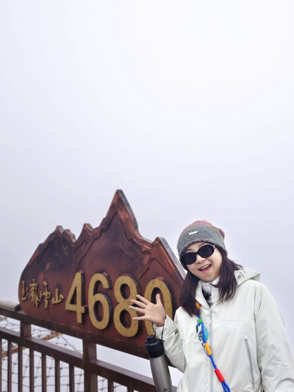 玉龙雪山4680米标志前开心挥手留影