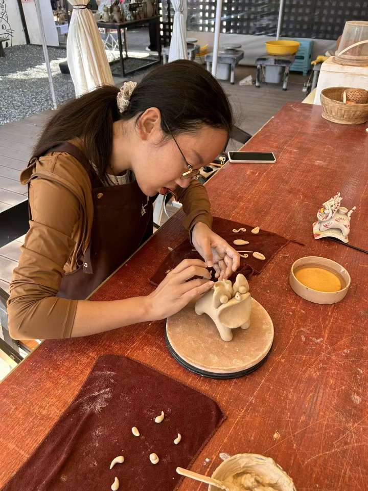 在工作室里专注捏瓦猫的侧影