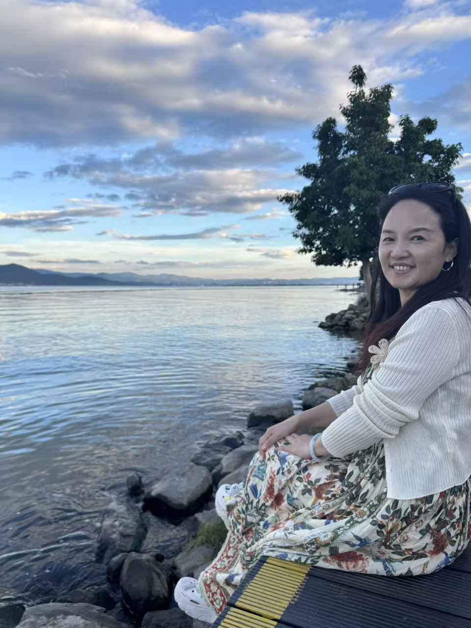 傍晚时分花裙女士坐在生态廊道木栈道上